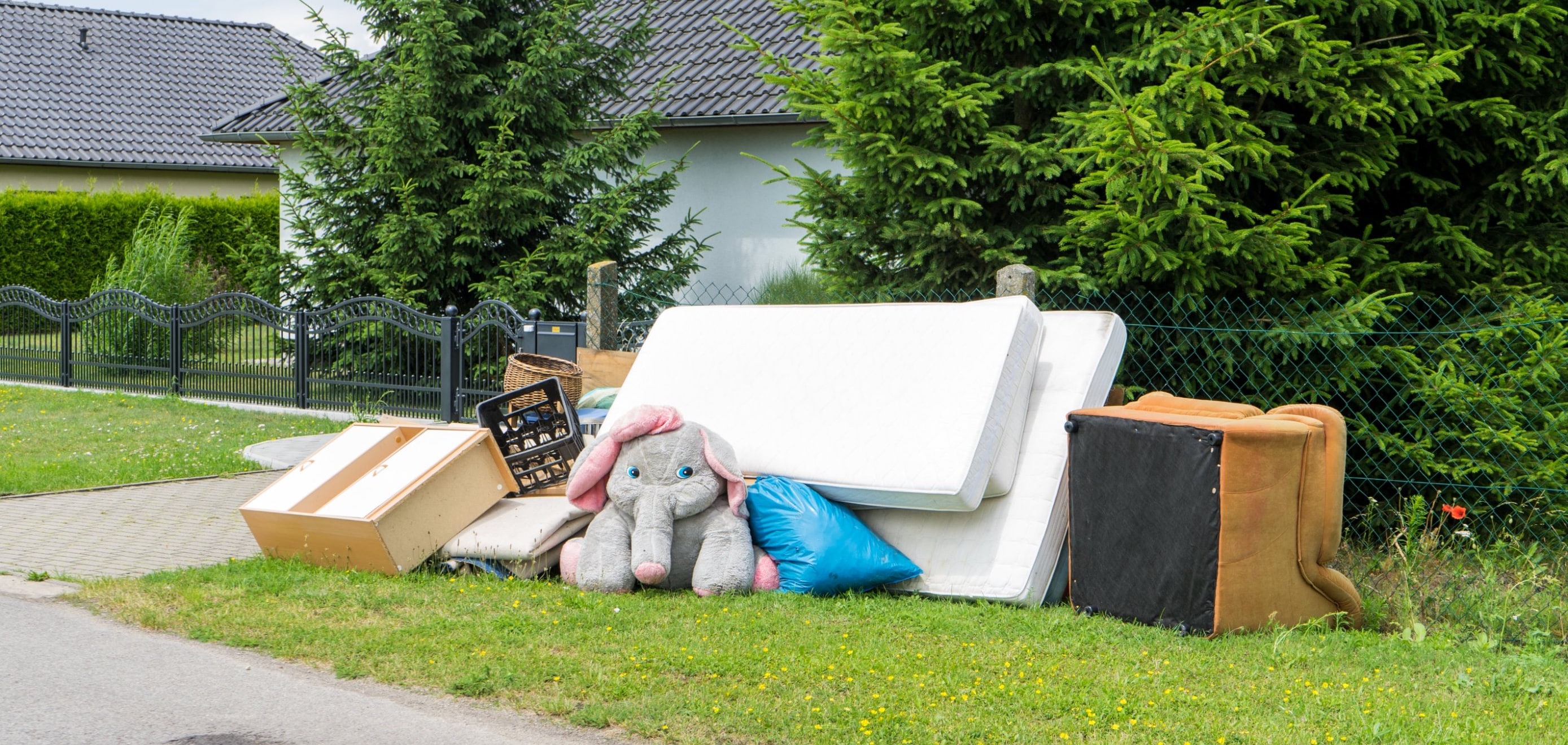 Pile of discarded furniture outside of a home