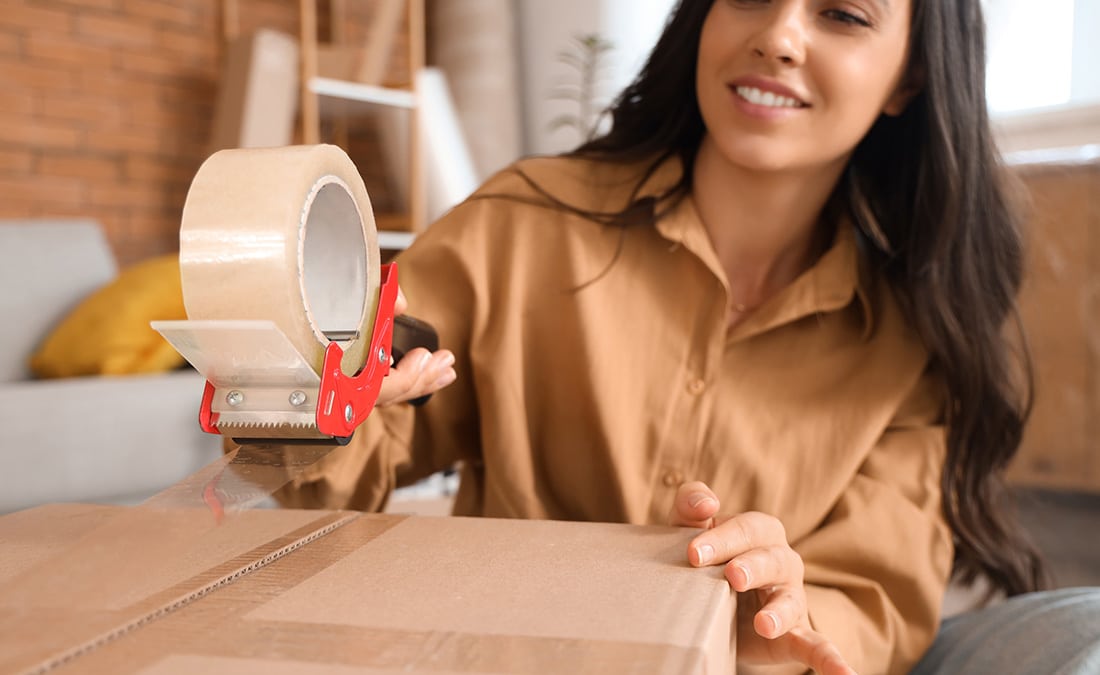 Woman taping up a moving box